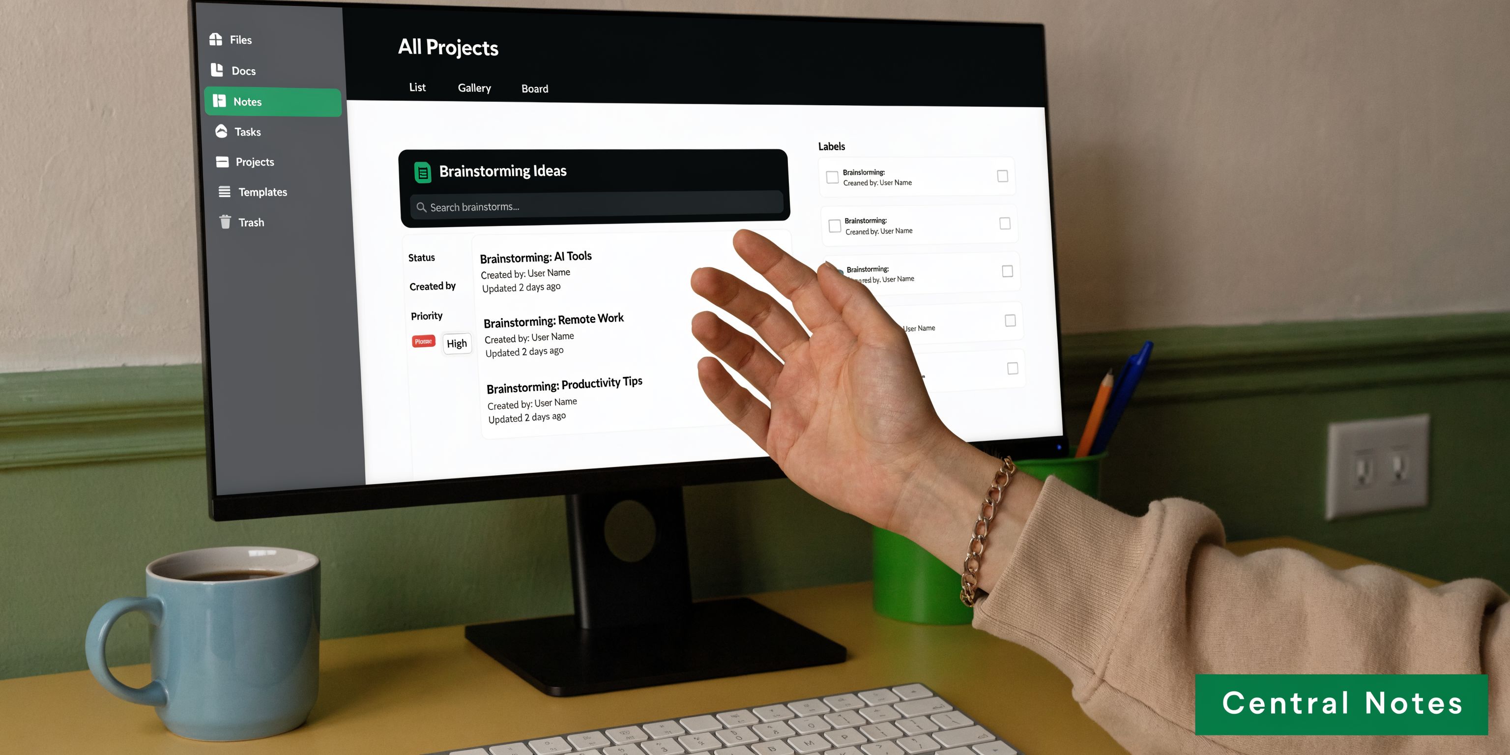 A person using a computer monitor displaying a project management dashboard for organizing notes and tasks.