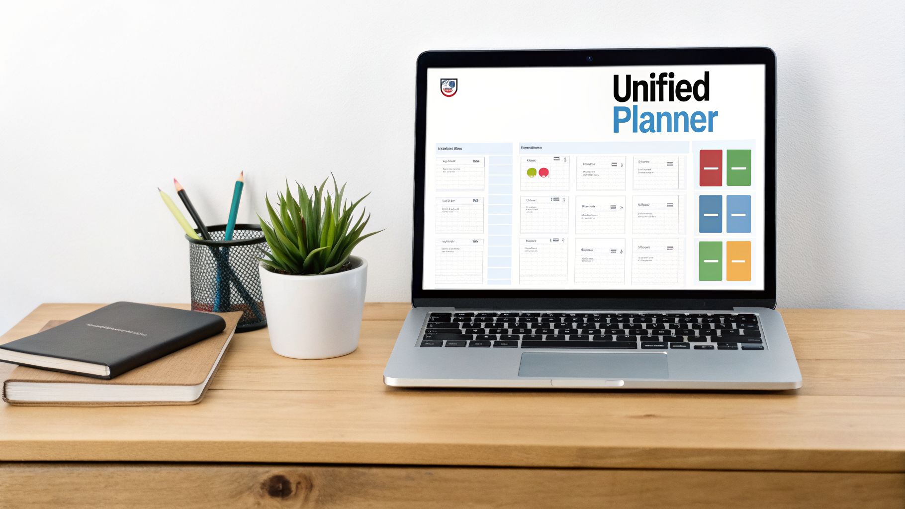 A laptop on a wooden desk displaying a 'Unified Planner' application, with office supplies and a plant.